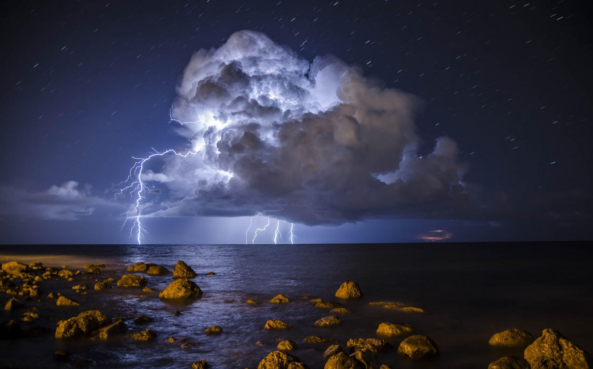 Storm sea rocks dark clouds lightning