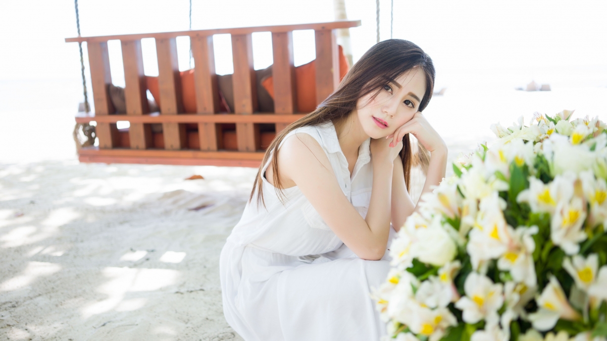 Long haired beauty in white dress and flowers