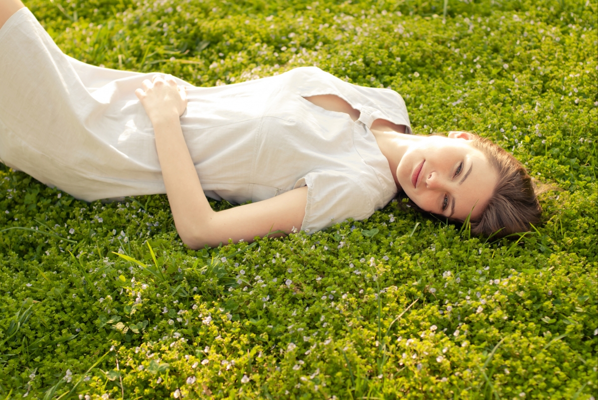 Beautiful smiling woman lying on the grass