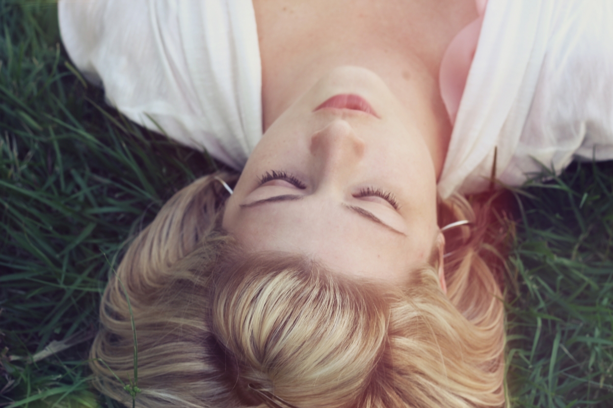 Beautiful blonde woman lying on the grass 5K