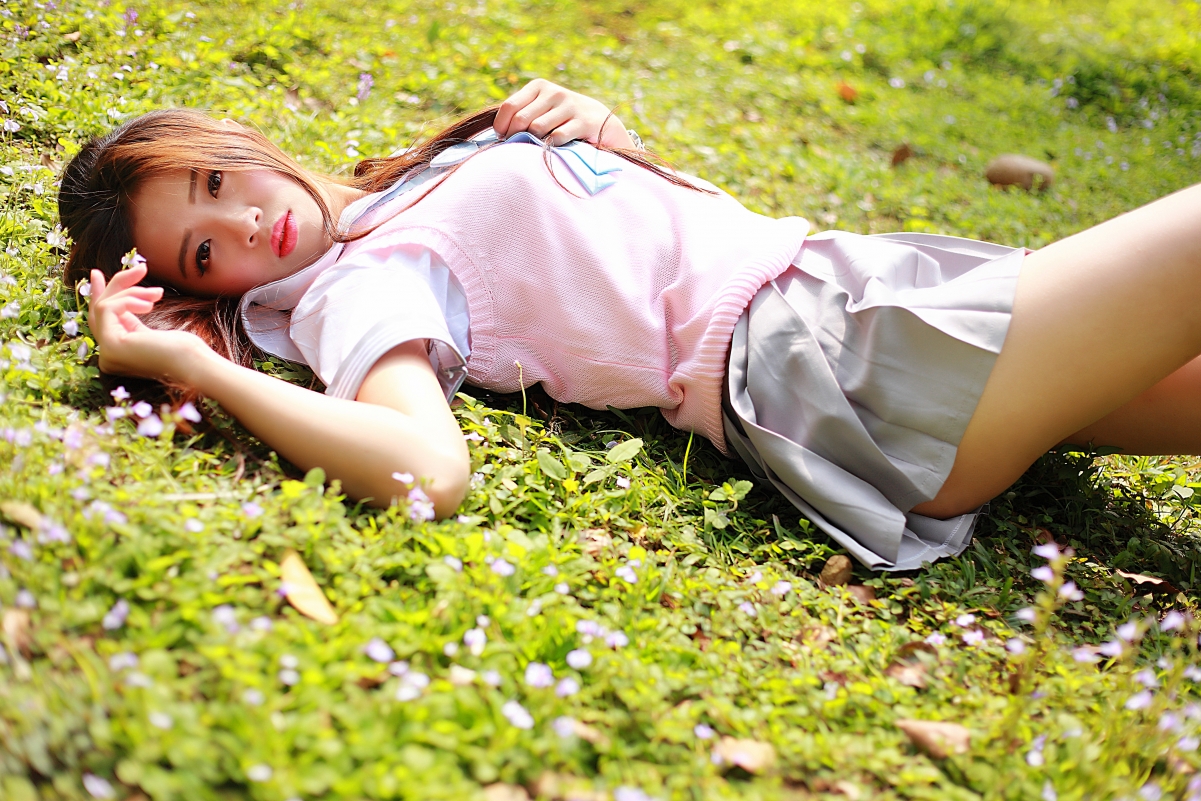 Beautiful girl in short skirt lying on the grass 4K