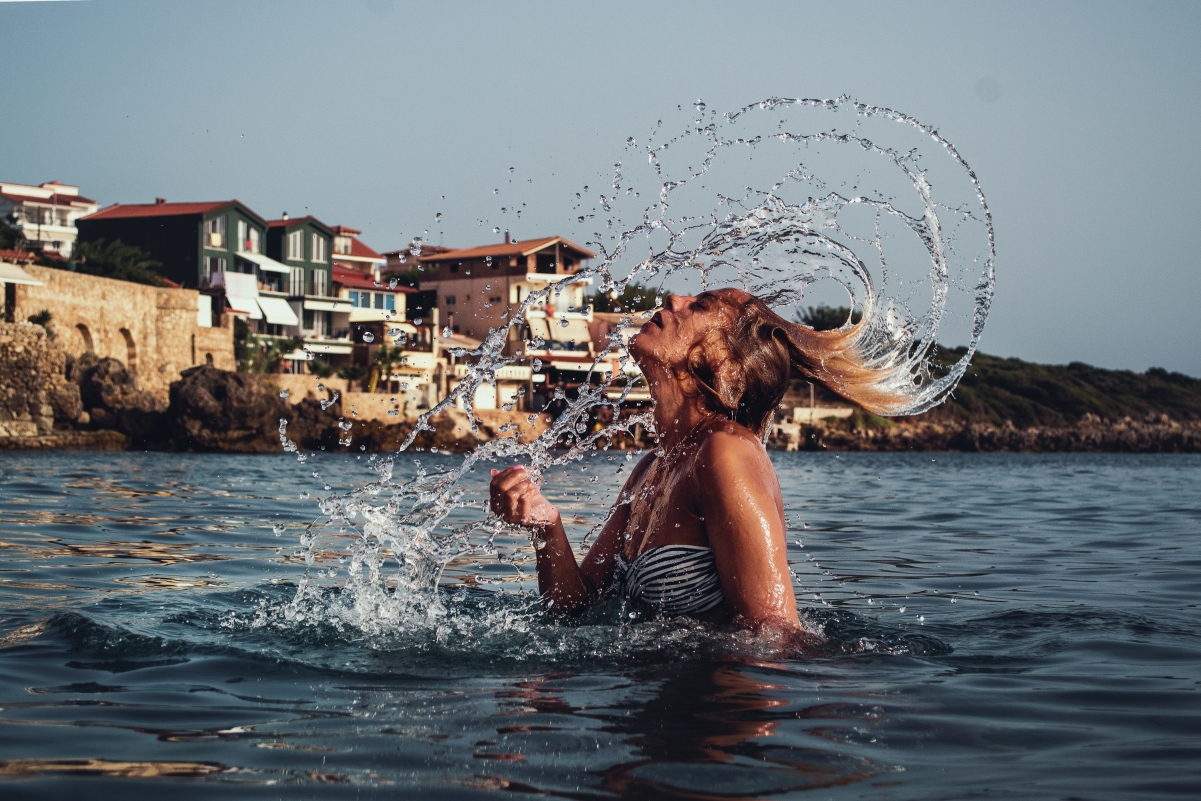 Beautiful girl sea with hair splashing water