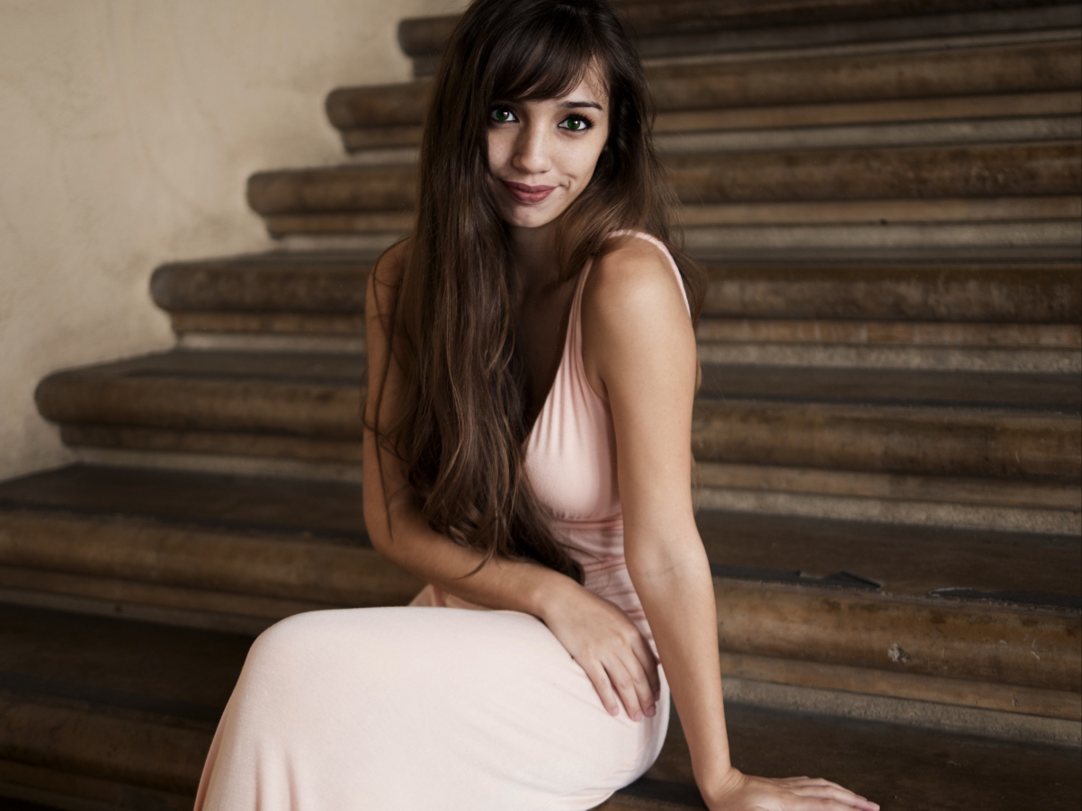 Woman sitting on stairs in long dress