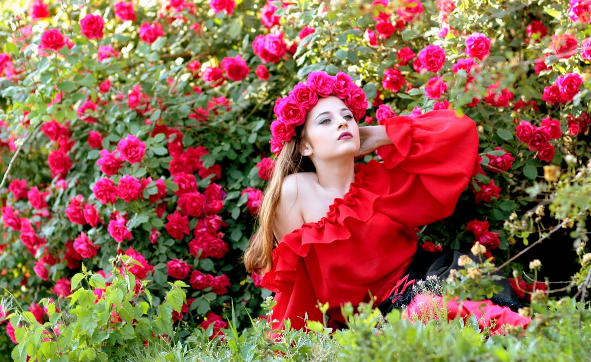 Girl with red wreath of fresh roses