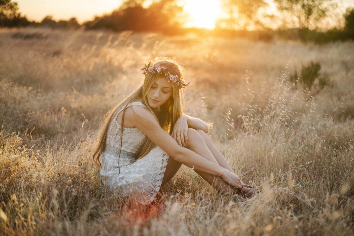 Girl blonde sitting pose grass