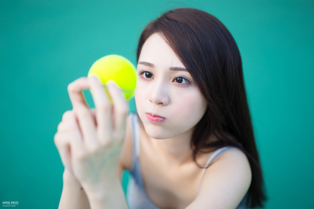 Cute tennis ball holding a tennis ball