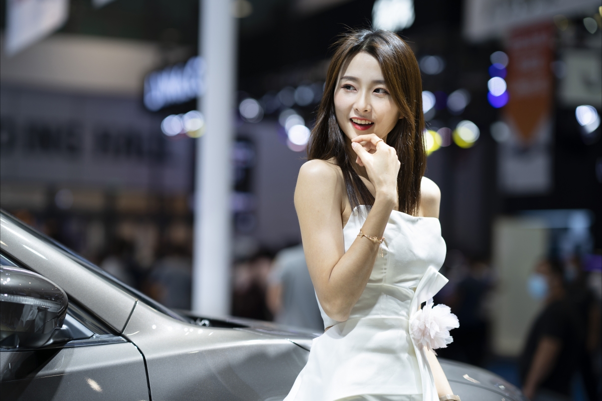 Beautiful car model with long hair and white skirt