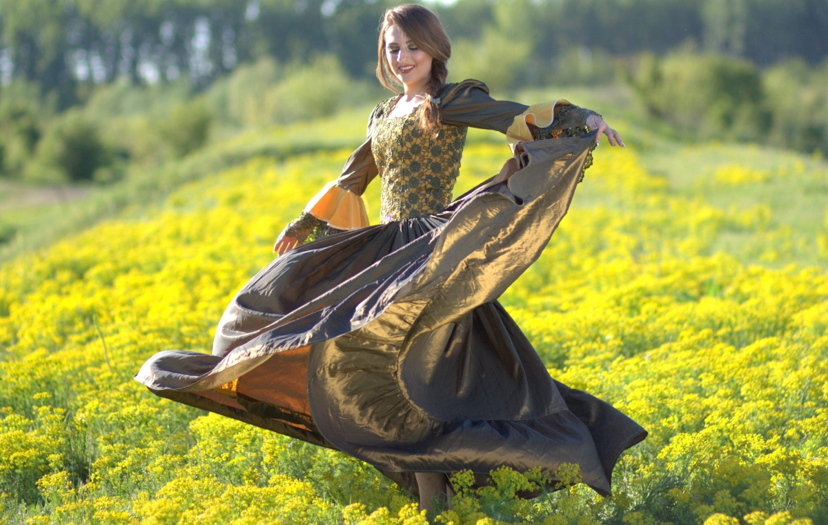Girl dancing with yellow canola flower