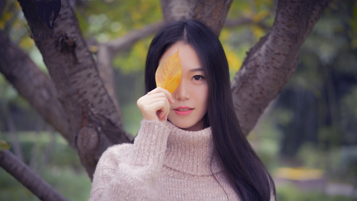 Outdoor long-haired beautiful woman leaves tree