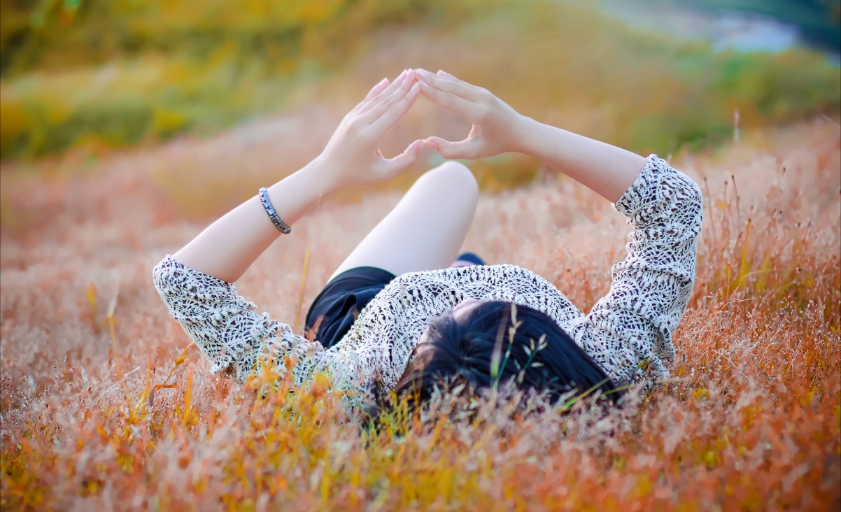 Beautiful caring hands lying flat on the grass